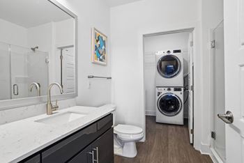 a bathroom with a toilet sink and a washing machine    and a laundry at Link Apartments® Mint Street, Charlotte, NC